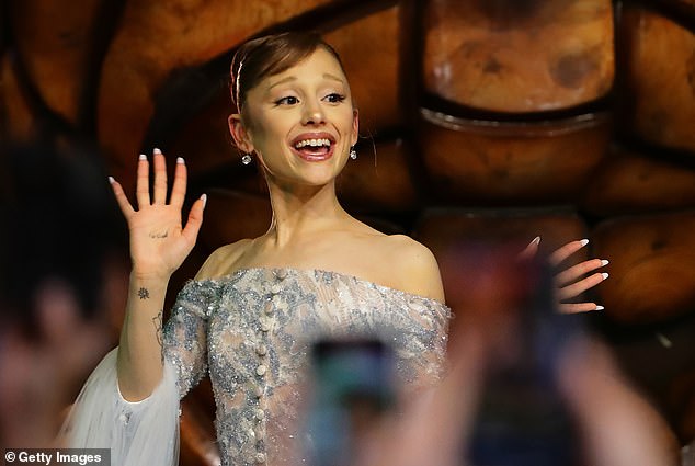 Ariana Grande waves to fans at the Wicked: For Good premiere in Singapore.