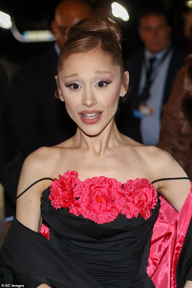 Ariana Grande on the Paris 'Wicked: For Good' red carpet, showing micro hand tattoos