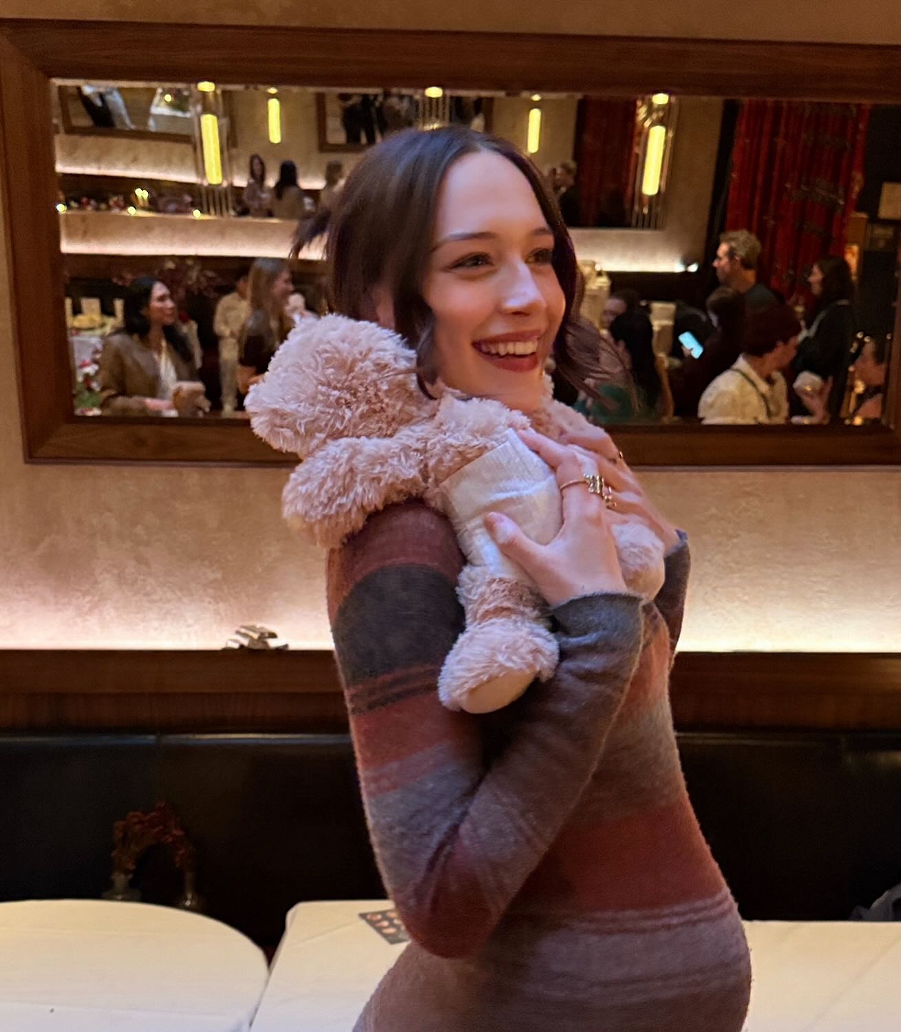 Elsie Hewitt hugging a freshly diapered teddy bear at the baby shower.
