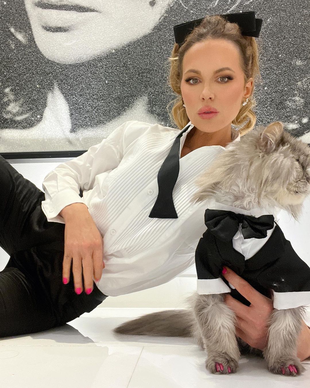 Kate Beckinsale with her cat in matching tuxedos, reflecting her offbeat social media humor.
