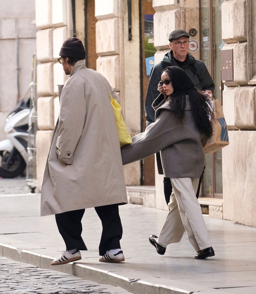 The couple walk down a Roman street during their late-November outing.