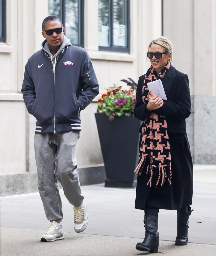 Amy Robach and T.J. Holmes walking in NYC, Robach smiling and wearing a large engagement ring.