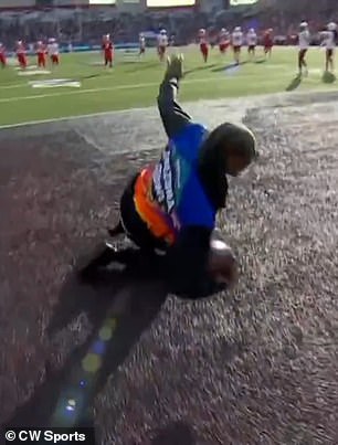 Snoop Dogg dives to the turf to snag a live kickoff during the Arizona Bowl