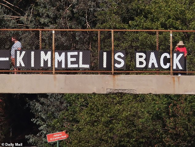 Supporters hold signs celebrating Jimmy Kimmel's return to the airwaves.