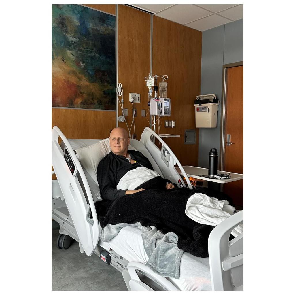 Dave Coulier in a hospital bed with an IV during cancer treatment.