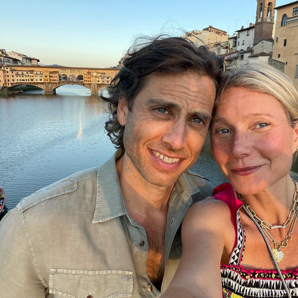 Gwyneth Paltrow and husband Brad Falchuk smile for a selfie with the Ponte Vecchio bridge in the background.