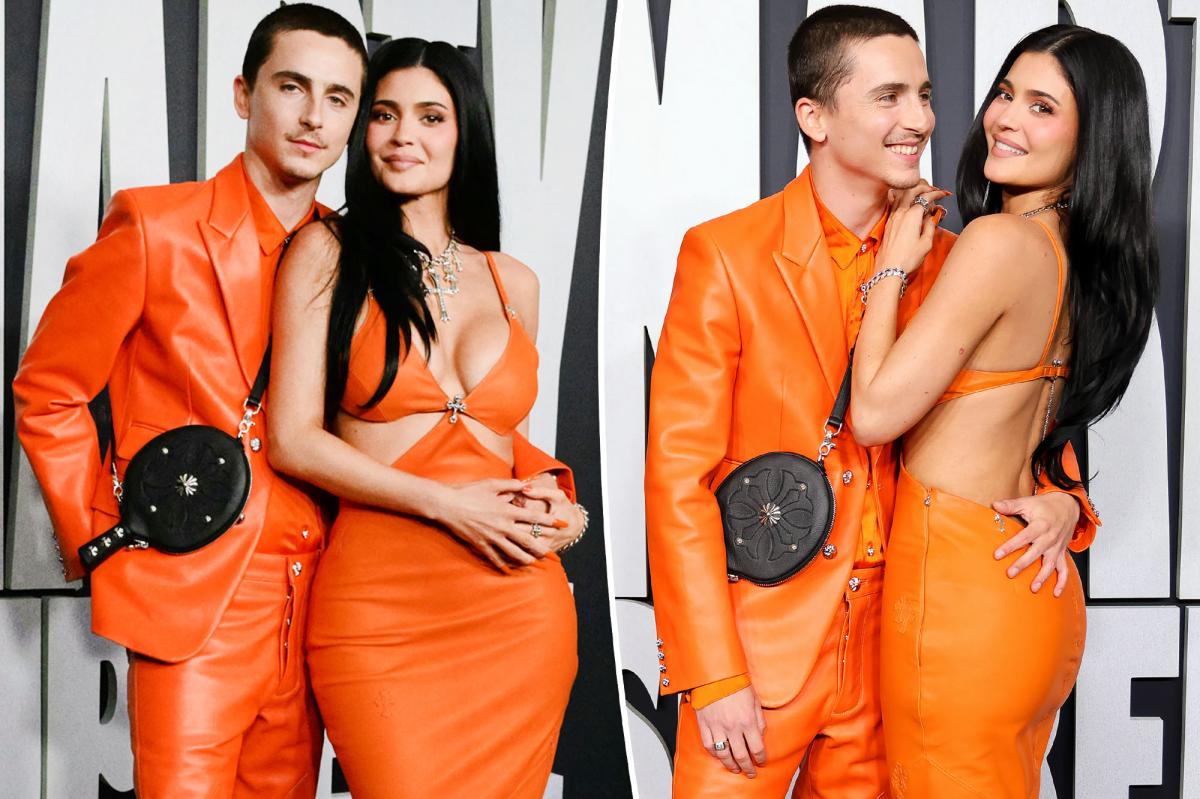 Kylie Jenner and Timothee Chalamet pose together in matching neon orange outfits on the Los Angeles red carpet for the Marty Supreme premiere; his arm around her waist.