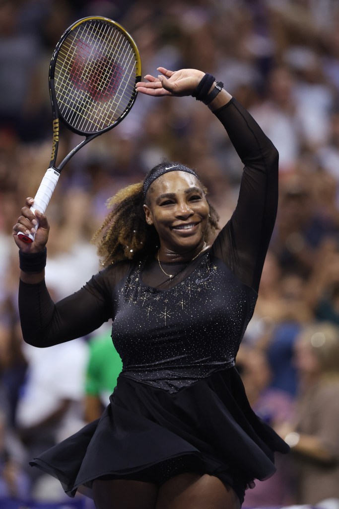 Serena Williams celebrates with her racket raised overhead after winning a match at the 2022 US Open.