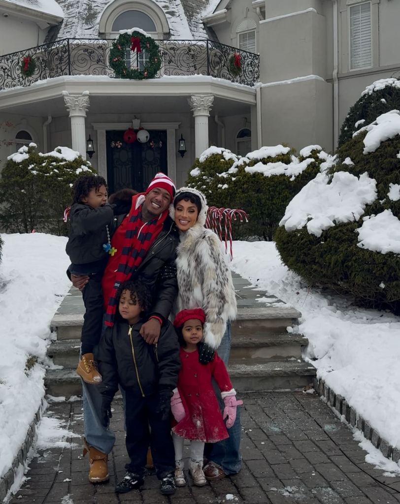 Nick Cannon and Abby De La Rosa with their three children posing in the snow.