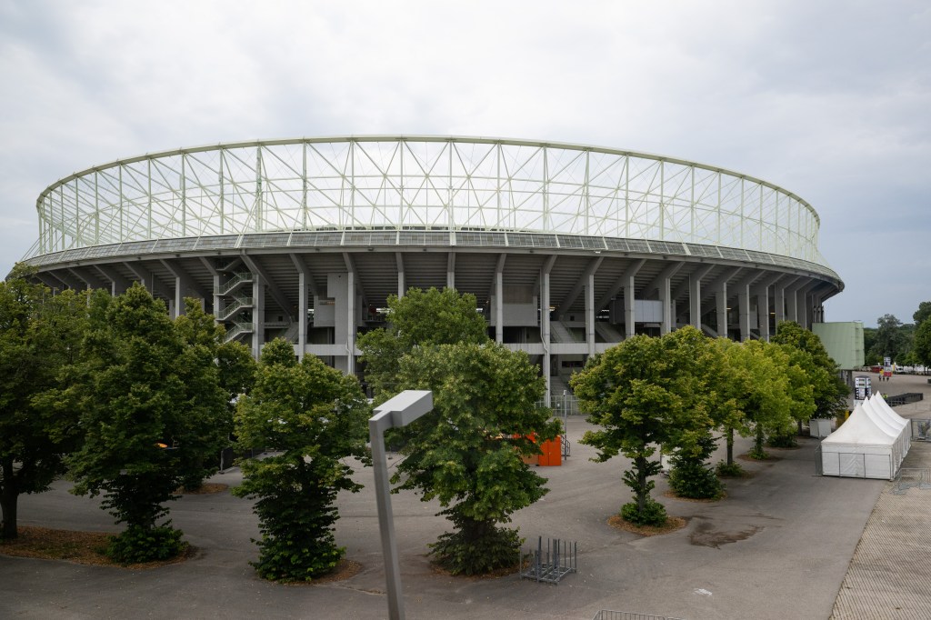 Exterior view of Ernst-Happel-Stadion in Vienna, Austria, with trees in the foreground.