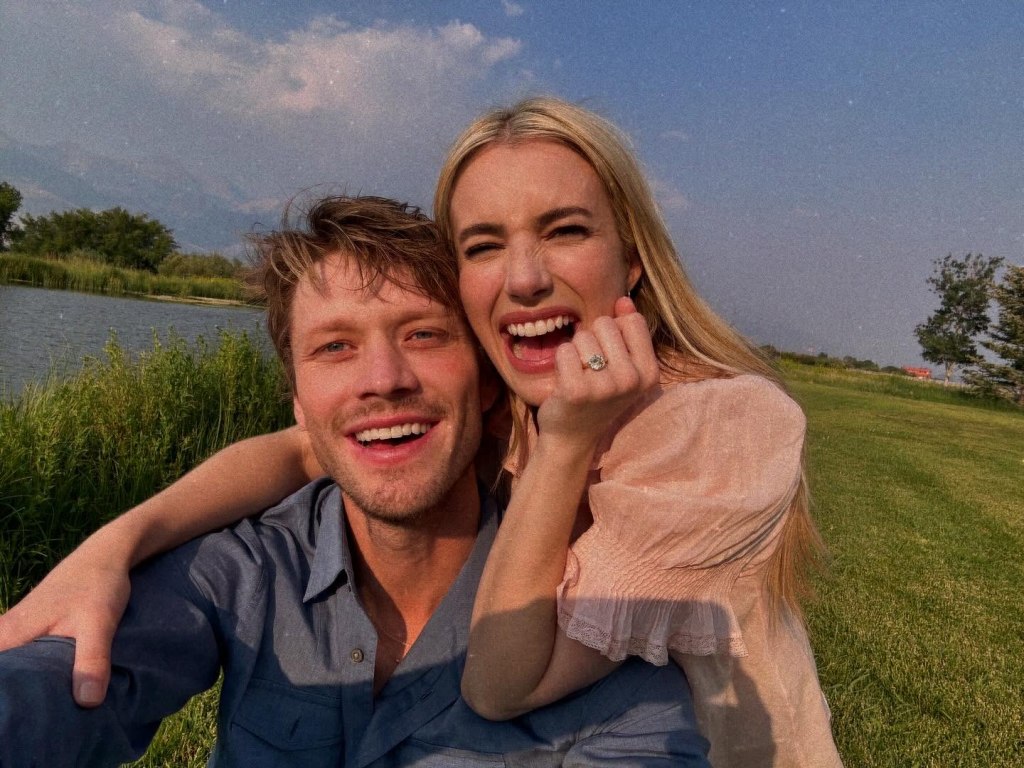 Emma Roberts showing her engagement ring while posing with her fiance Cody John.