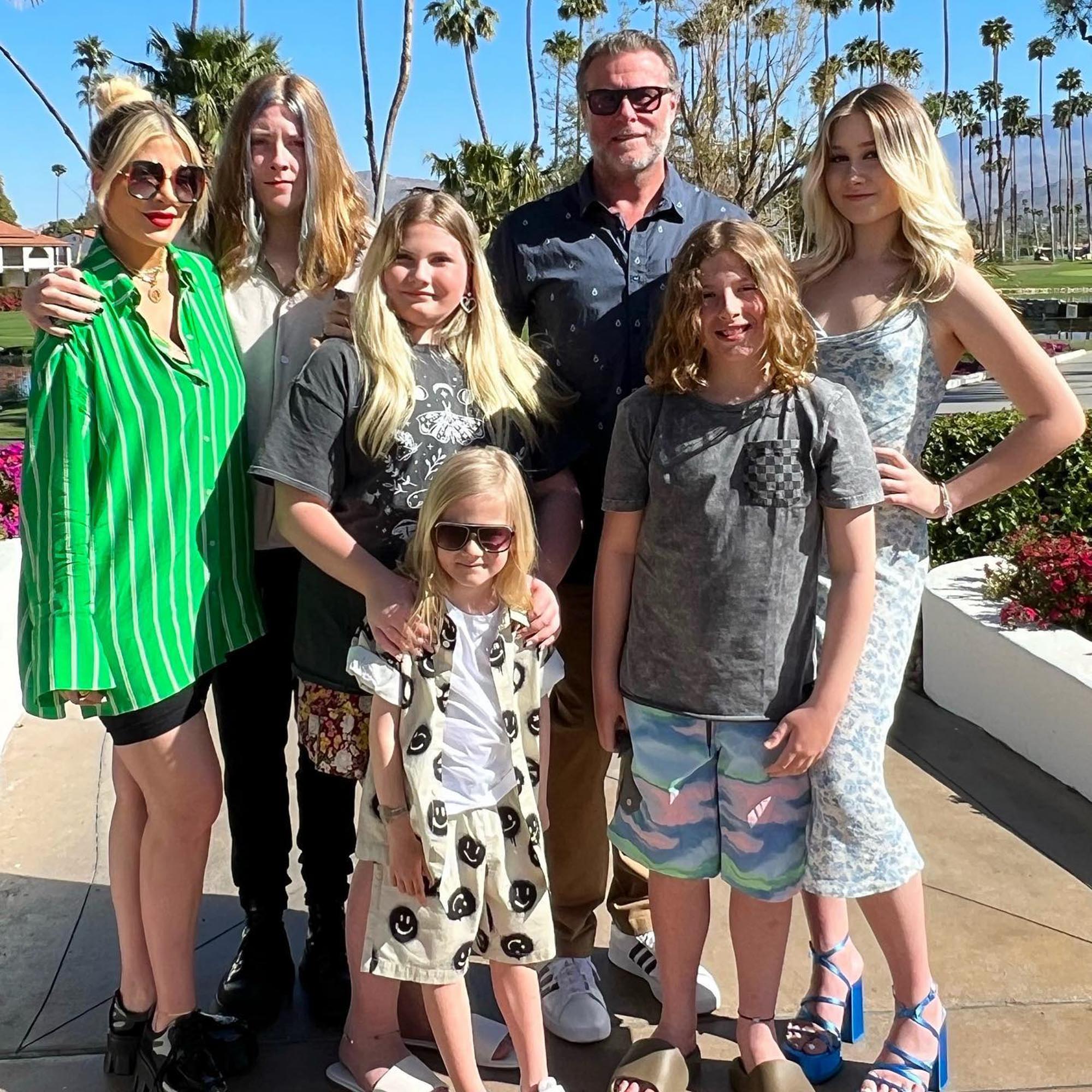 Tori Spelling, Dean McDermott, and their five children pose together outdoors.