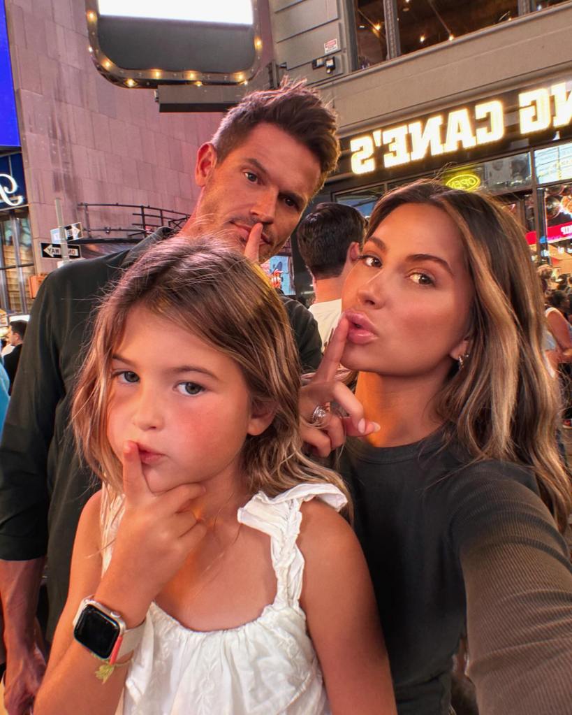 Demi Engemann and her husband Bret along with their daughter pose with their fingers over their lips.