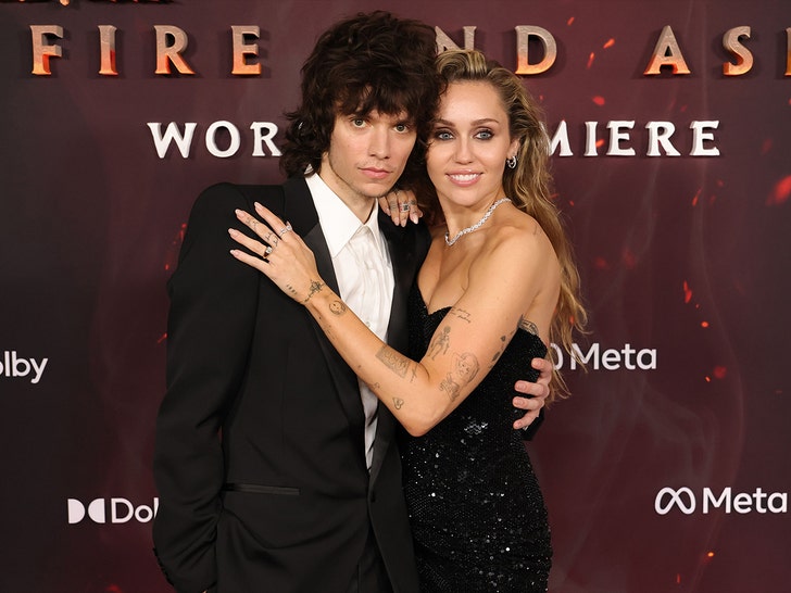 Miley Cyrus and Maxx Morando at the Avatar: Fire and Ash premiere; Cyrus rests her left hand on his chest, displaying a diamond ring.