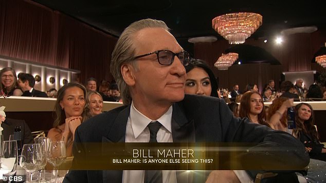 Maher appears puzzled, then stone-faced, as the audience laughs around him