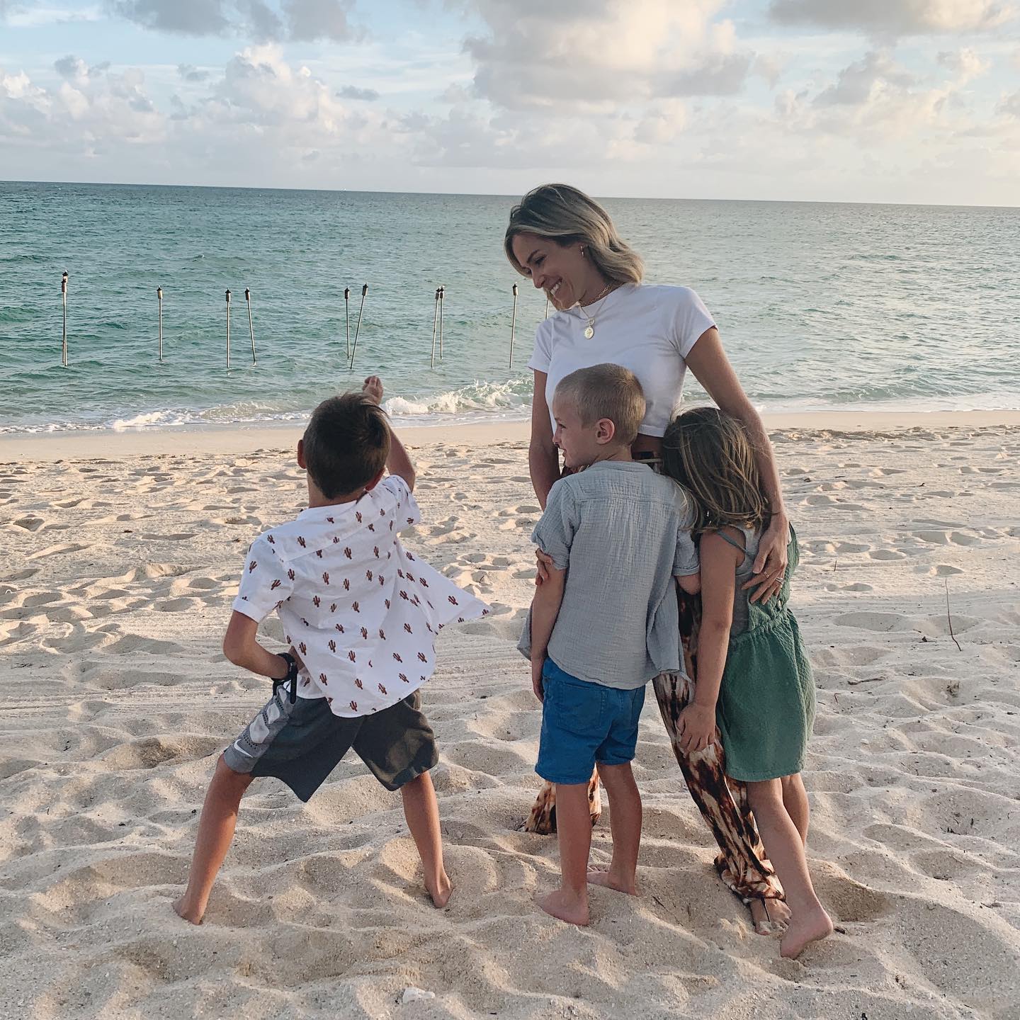 Kristin Cavallari smiling with her three children on a beach.
