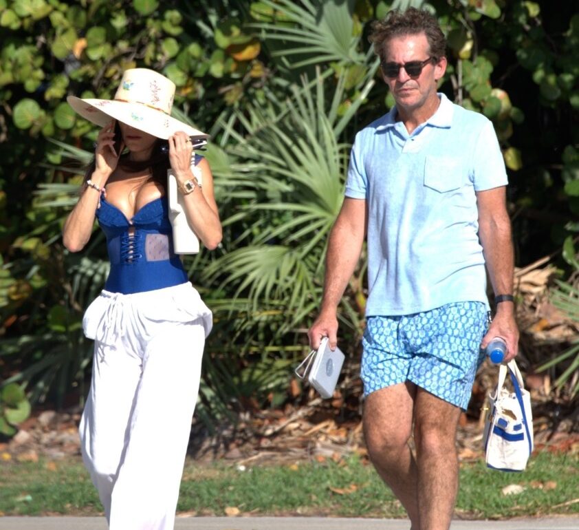 Bethenny Frankel in a blue lace-up bustier and white drawstring pants walking with a man in Miami; the pair appeared to be headed to the beach.