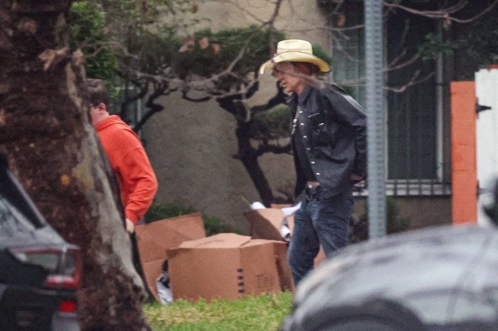 Mickey Rourke walking with a companion carrying cardboard boxes amid reports about back rent and eviction.