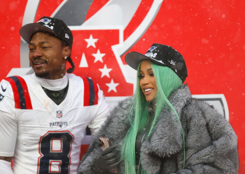 Cardi B and Stefon Diggs share a celebratory kiss on the field after the AFC Championship.