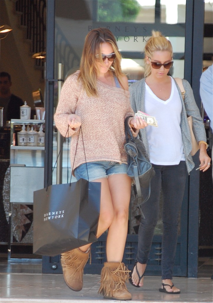Haylie Duff exits Barneys New York carrying a shopping bag as Ashley Tisdale walks beside her.