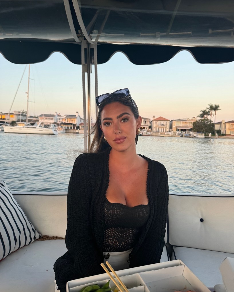 Samantha Leonard on a boat with a coastal town in the background.