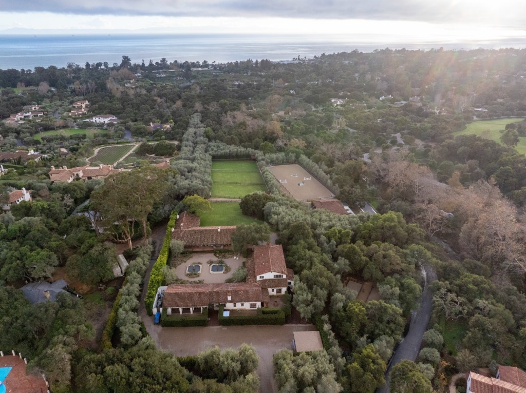 Aerial view of Kendall Jenner's six-acre Montecito property with six small homes, equestrian facilities, and the ocean in the background.
