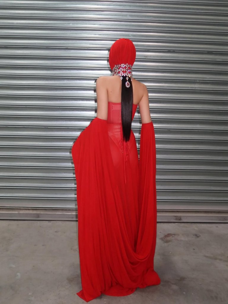 Backstage, Jennie tries the full hooded Margiela look with a crystal headpiece.