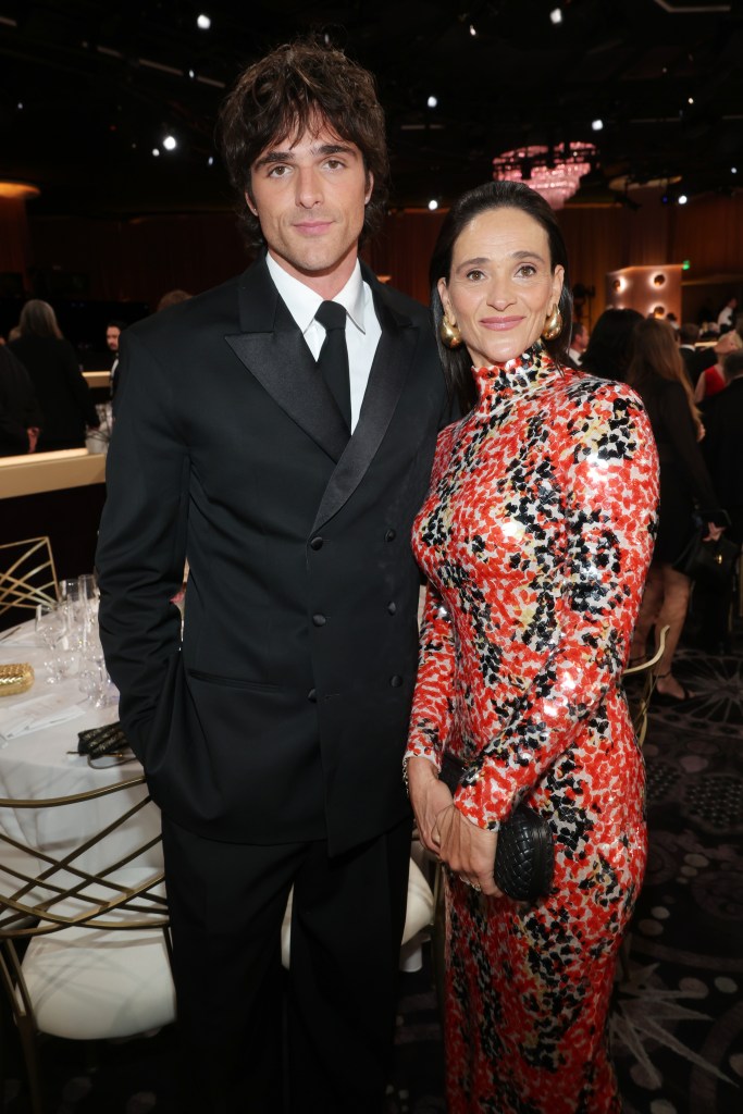Jacob Elordi in a black tuxedo with his mother, Melissa Elordi, in a red, white, and black patterned dress at the Golden Globes.