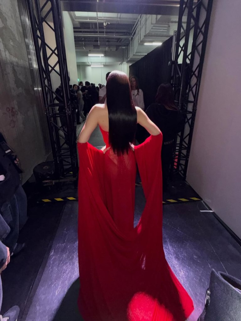 Back view of Jennie's red Margiela gown with its sweeping train and draped sleeves.