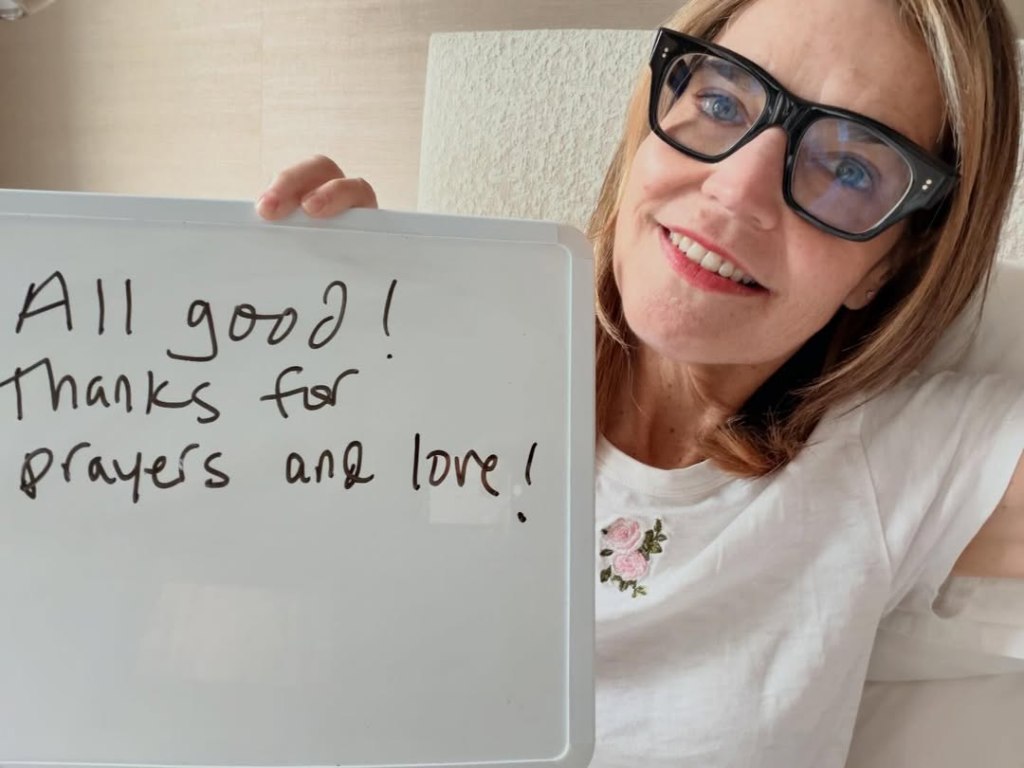Savannah Guthrie holding a whiteboard that reads, "All good! Thanks for prayers and love!"