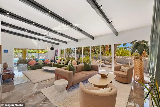 Living room with vaulted ceilings and near floor-to-ceiling glass opening to the pool