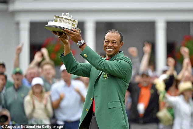 Tiger Woods holding a trophy in a previous tournament