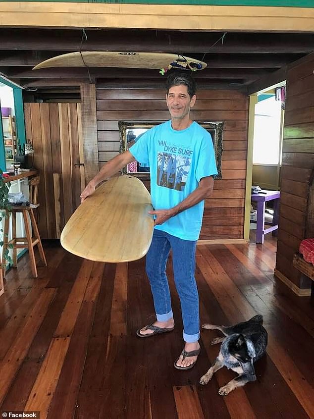 Kurt Van Dyke standing with a surfboard.