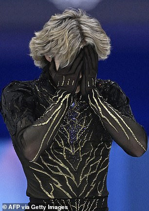 An emotional Ilia Malinin covers his face after finishing his free skate in Milan.