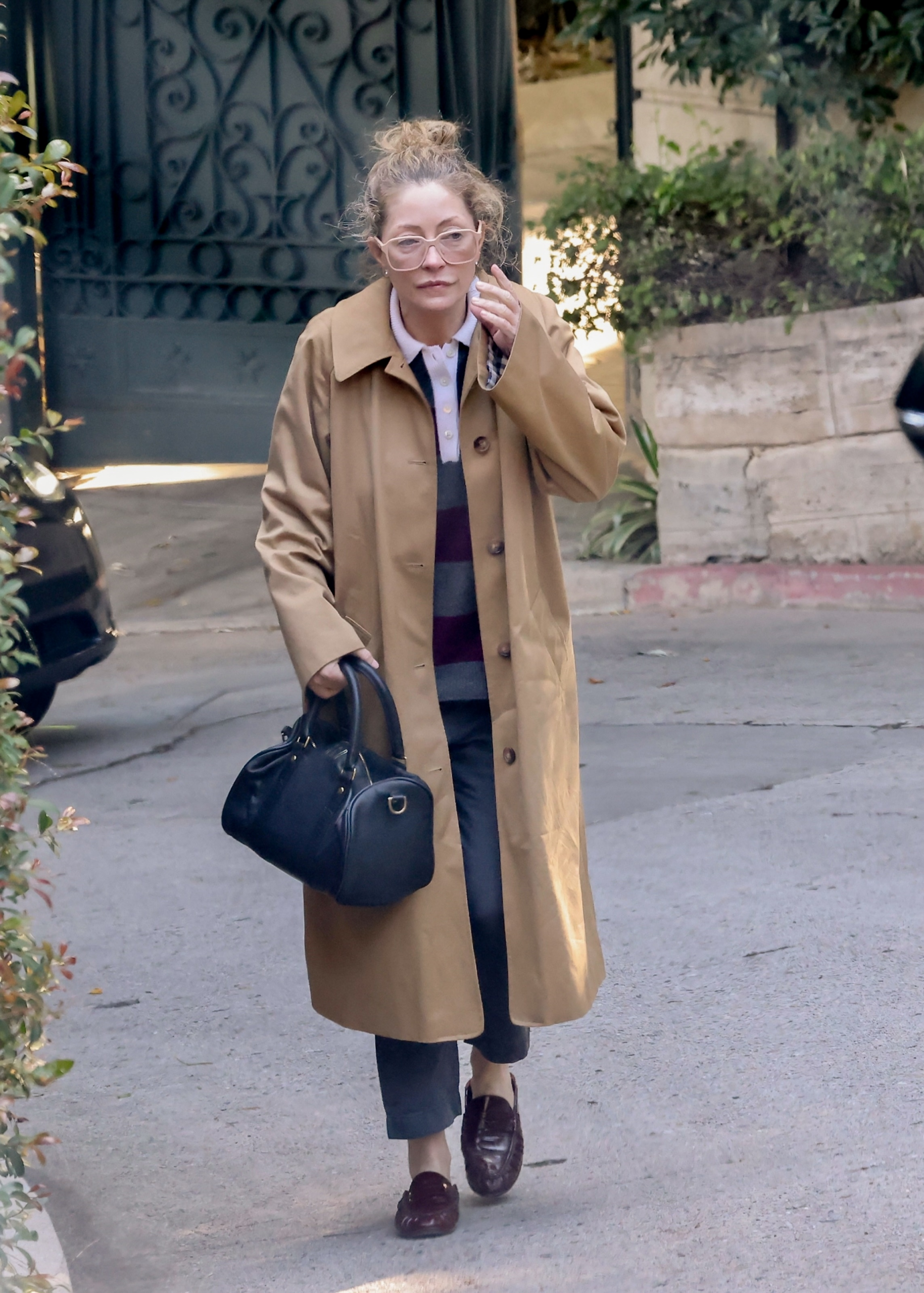 Rebecca Gayheart leaving the Los Angeles home where Eric Dane had been living before his death, wearing a beige trench coat and glasses.