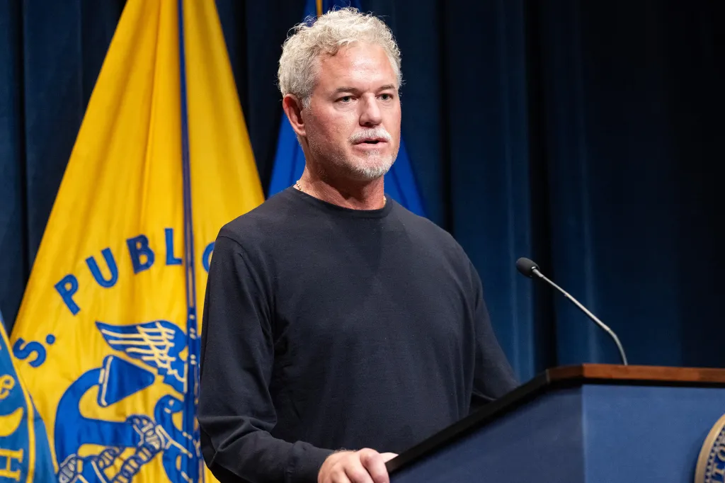 Eric Dane speaking at a podium about his ALS diagnosis.