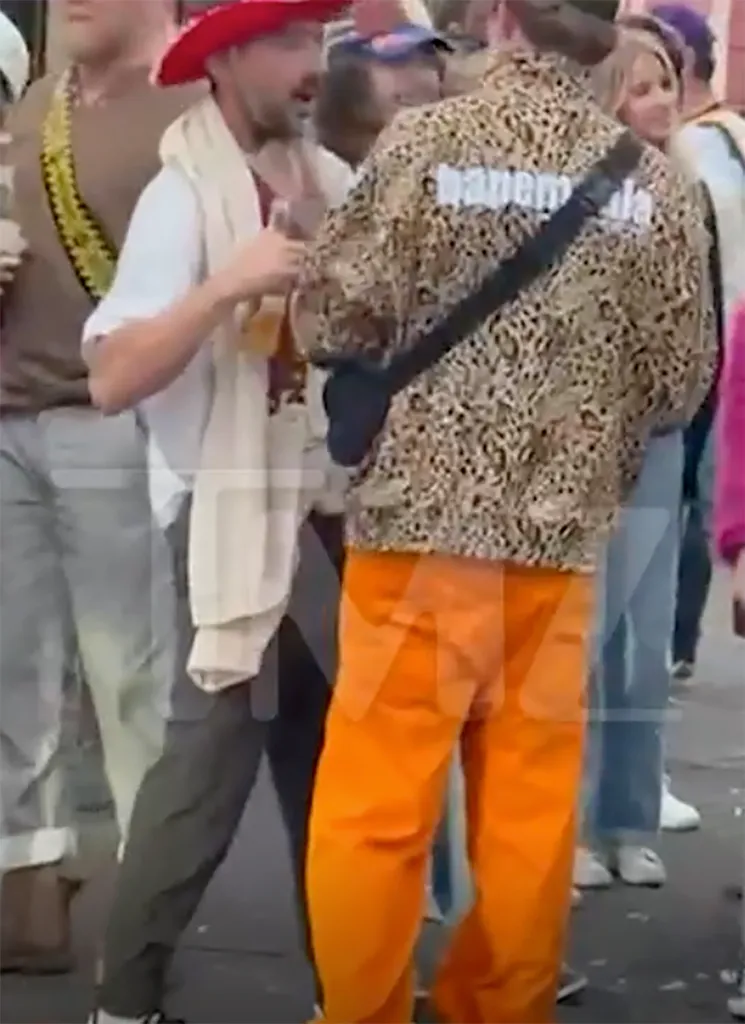 Shia LaBeouf wearing a red cowboy hat and holding a drink during Mardi Gras after his release from custody.