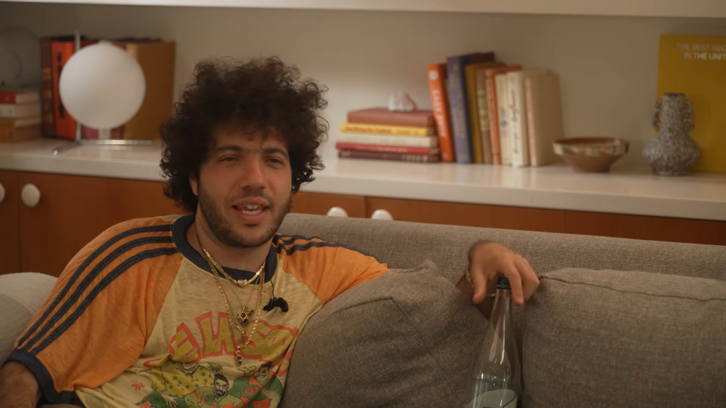 Benny Blanco sits on a couch during the debut Friends Keep Secrets podcast episode.