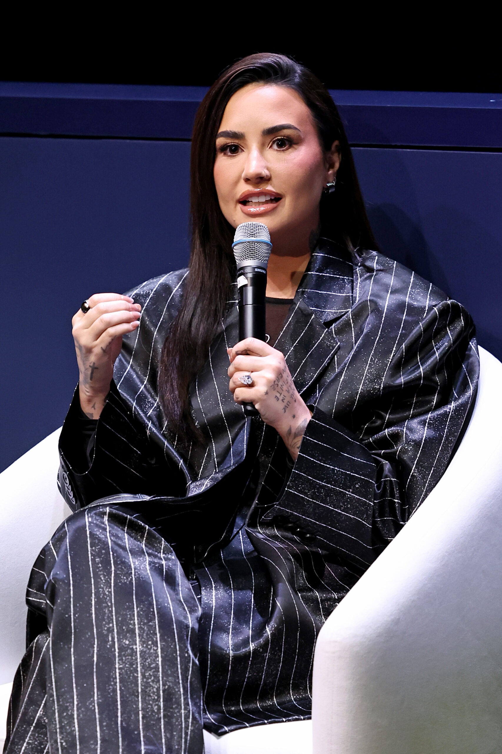 Demi Lovato speaking onstage at the Project Healthy Minds World Mental Health Day Festival.