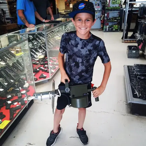 Anthony Zecca, 13, holding a firearm in a gun store.