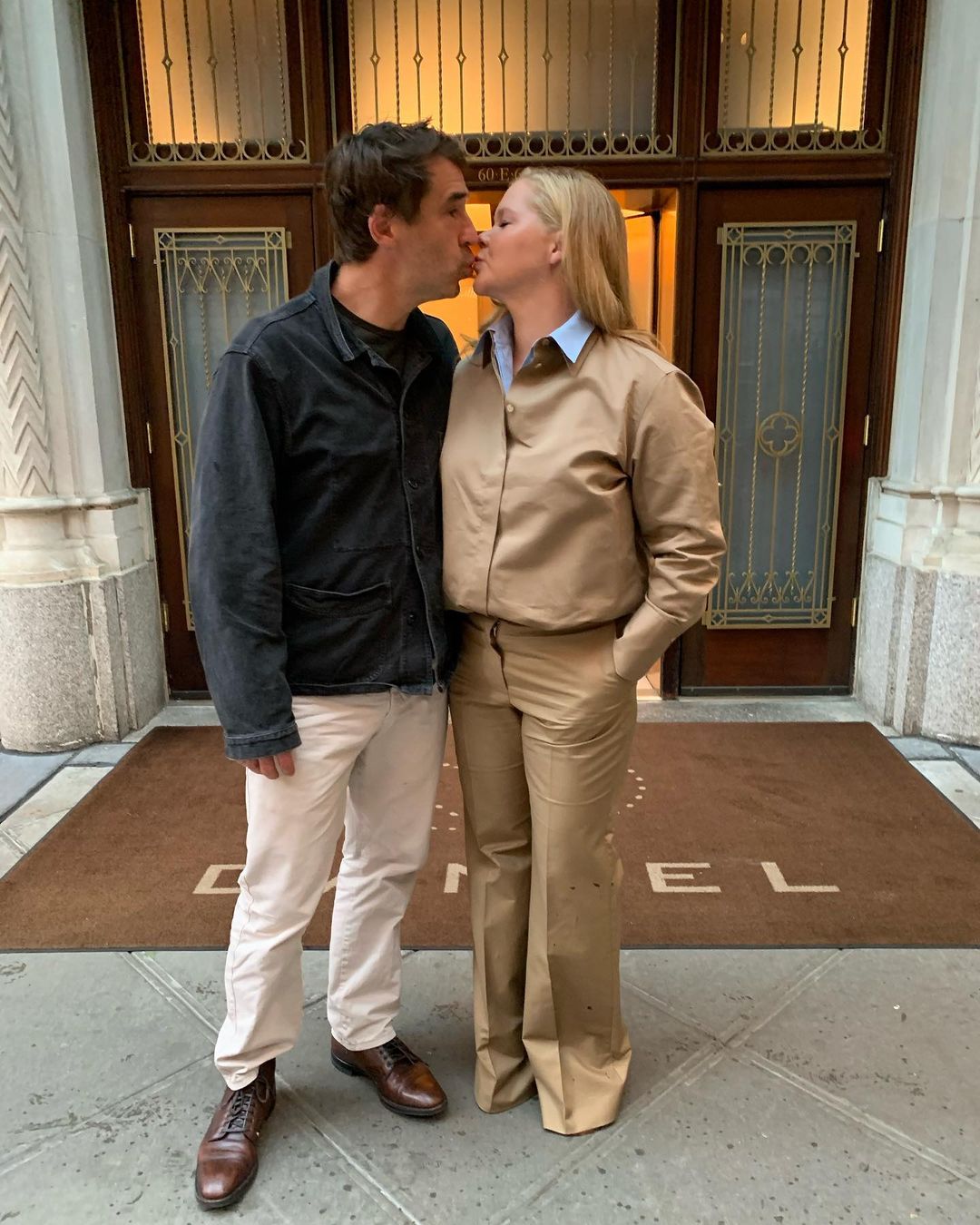 Amy Schumer and husband Chris Fischer share a kiss in an earlier photo; the comedian filed for divorce in January.