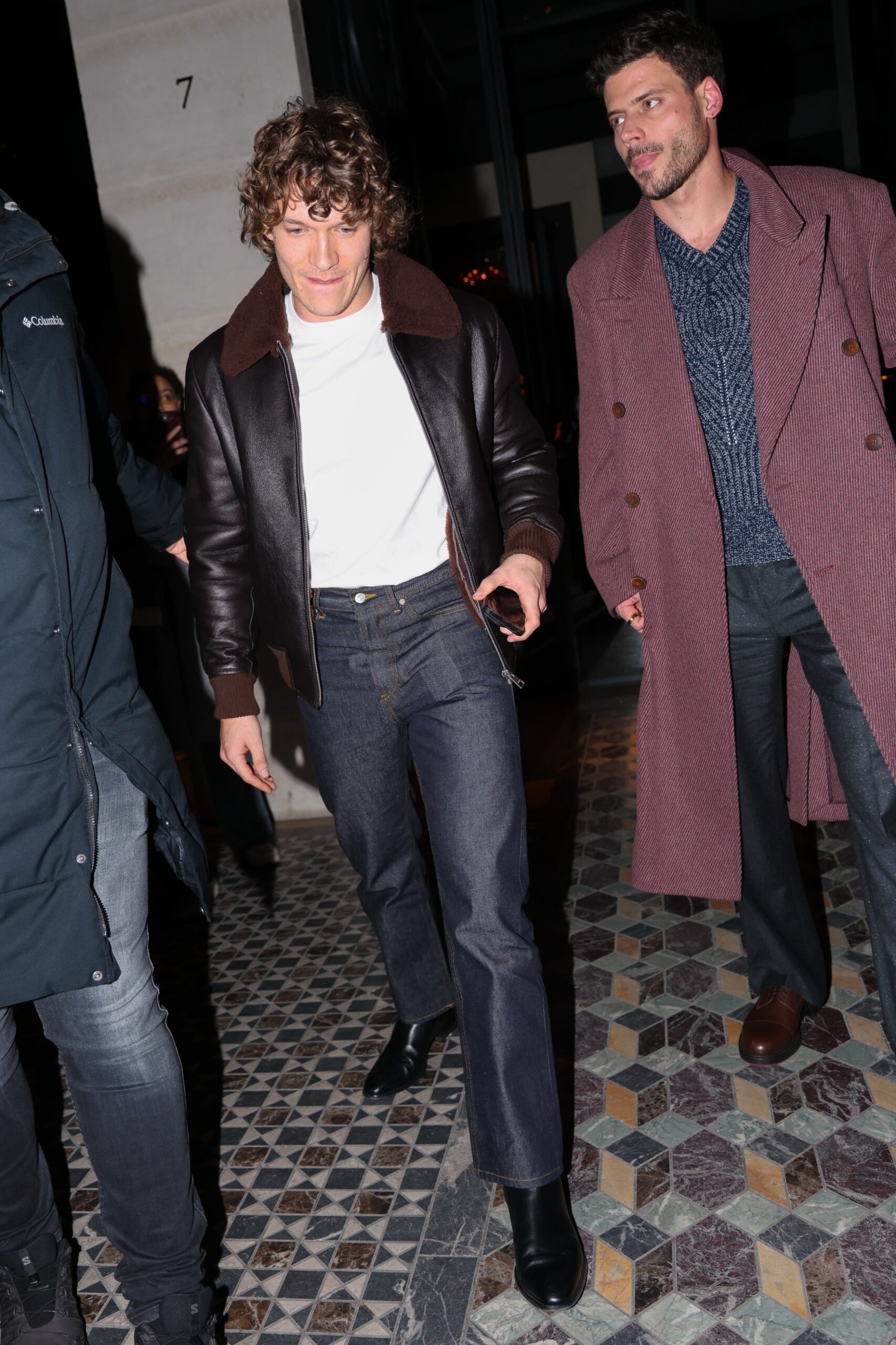 Connor Storrie in a leather jacket and Francois Arnaud in a burgundy coat enjoying a night out in Paris.