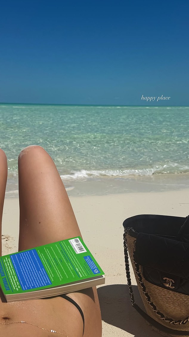 Kylie Jenner shares a beach-read POV-legs, book, sand, and sea-captioned as her 'happy place'