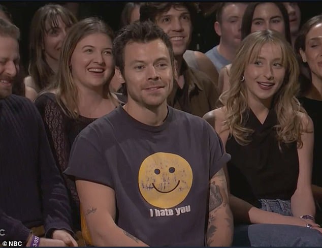 Harry Styles sits calmly in the audience as the camera finds him during Gosling's SNL monologue.
