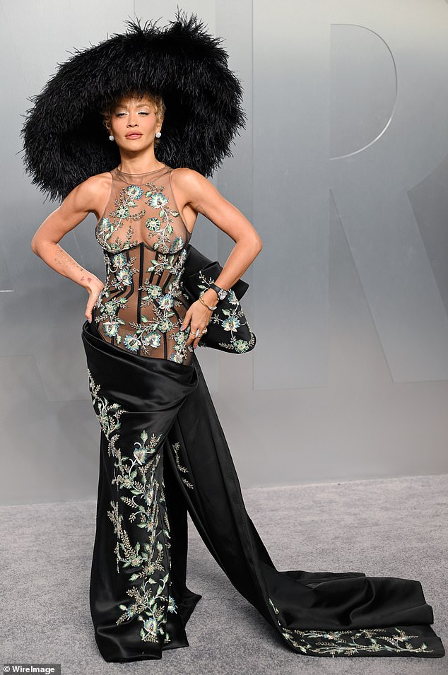 Rita Ora in a sculptural headpiece and semi-sheer corseted look at the Vanity Fair Oscar Party