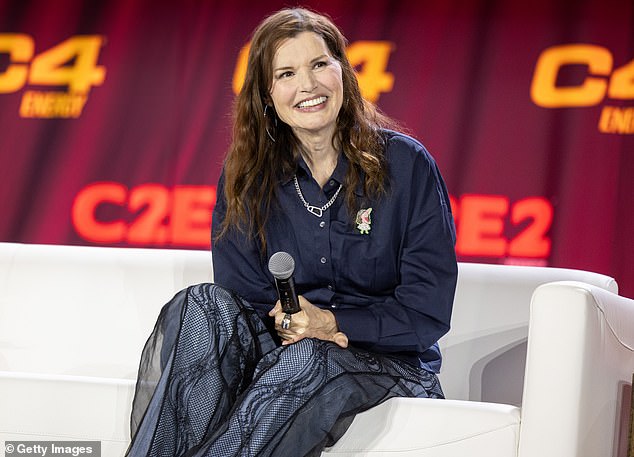 Geena Davis speaks on stage during a Q&A, wearing a navy top and dark gray trousers.