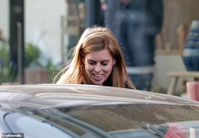 Princess Beatrice smiles as she gets into an electric Porsche after lunch in Notting Hill