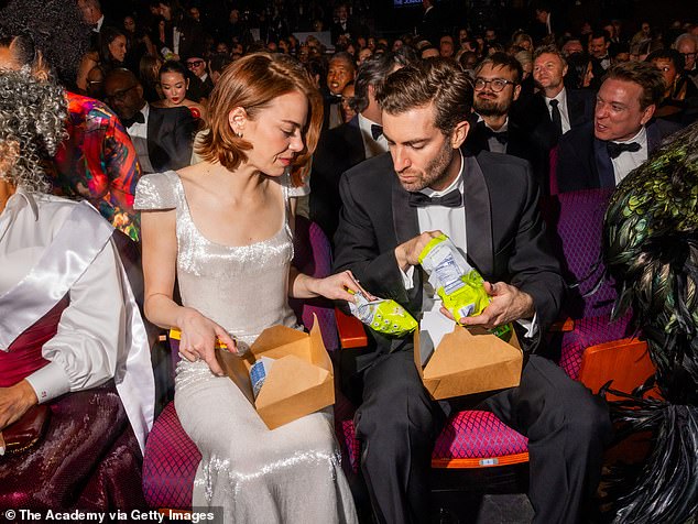 Attendees with snack boxes under their seats at the Oscars, a nod to the show's long runtime.