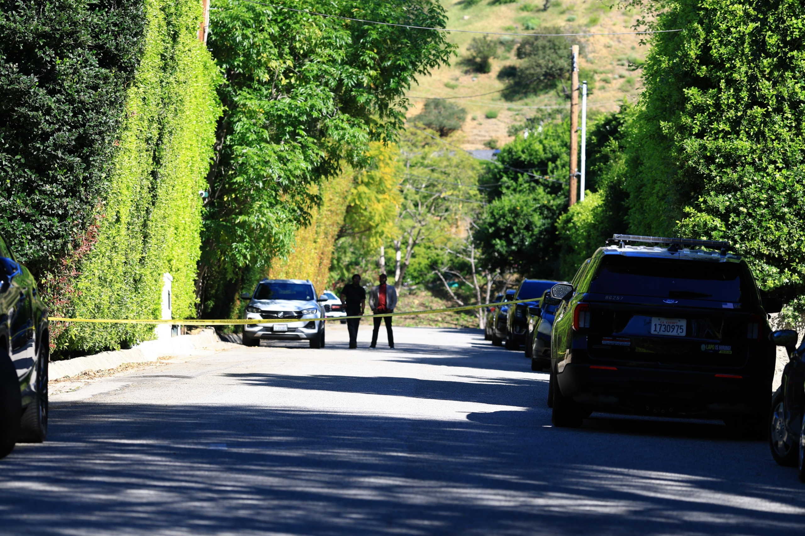 Police tape blocks a residential street in Beverly Hills near Rihanna's residence following reports of gunfire.