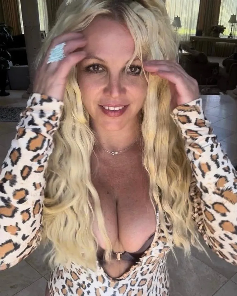 Britney Spears smiles at the camera in a leopard print top, 2023.